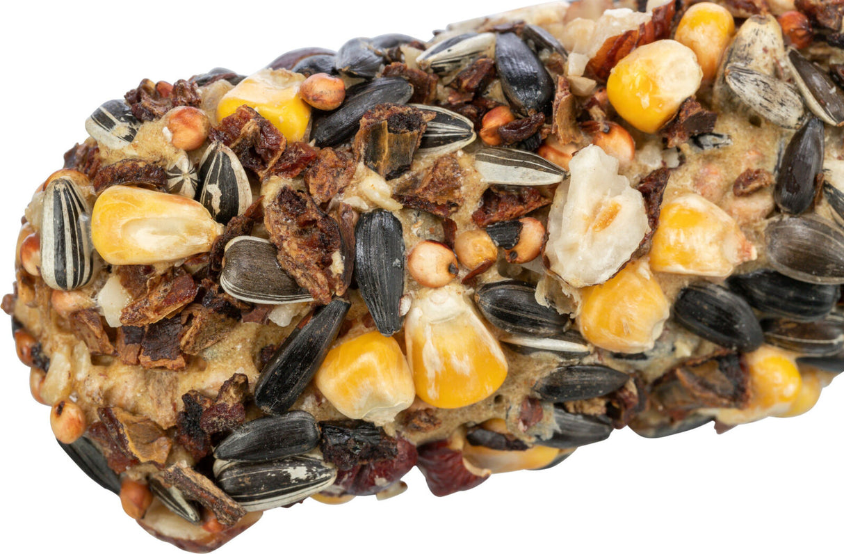 Nahaufnahme eines gemischten Vogelfutterriegels mit Sonnenblumenkernen, gelbem Mais und getrockneten Früchten.