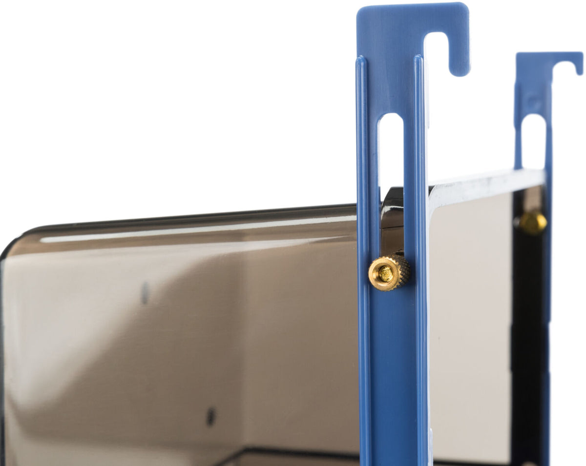 Zwei blaue Halterungen mit goldenen Schrauben fixieren eine schwarze, glänzende Platte.