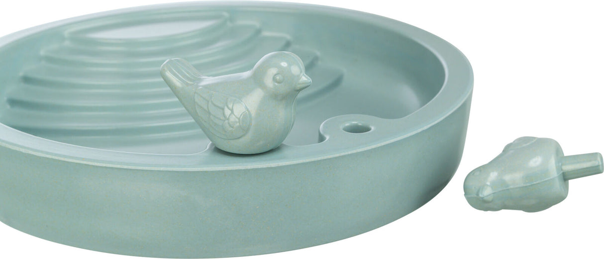 Runde, grüne Schale mit erhöhtem Rand und stufenförmigem Inneren, verziert mit einer kleinen Vogelstatue.
