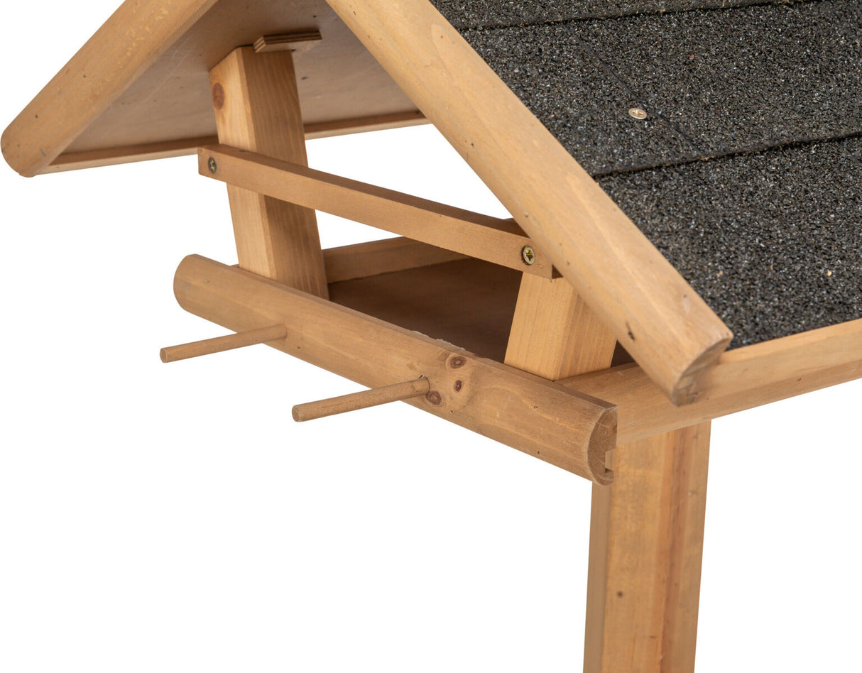 Holzvogelhaus mit schrägem, dunkel gedecktem Dach und seitlichen Stangen zur Anbringung von Futter.