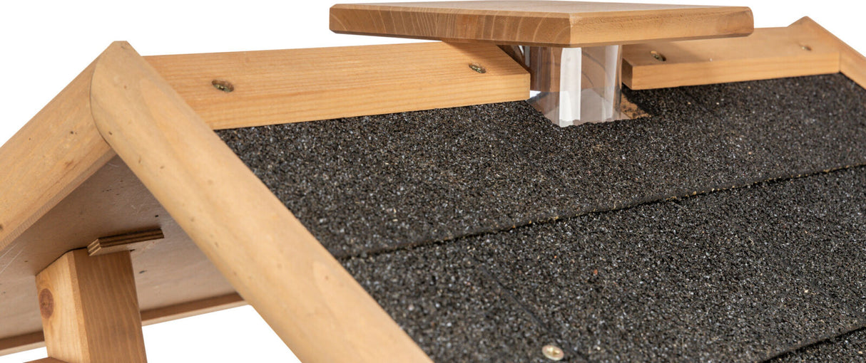 Dachkonstrukt aus Holz mit schwarzer, körniger Dachbedeckung und durchsichtigem Element unter kleinerer Holzplatte.