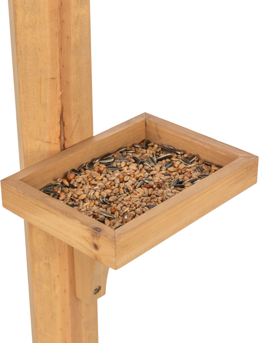 Holzrahmen mit gestreuten Körnern gefüllt, montiert auf vertikalem Holzpfosten.