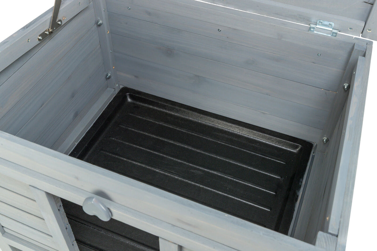 Offene graue Holzbox mit schwarzem Boden und Metallscharnieren an der Innenseite des Deckels.