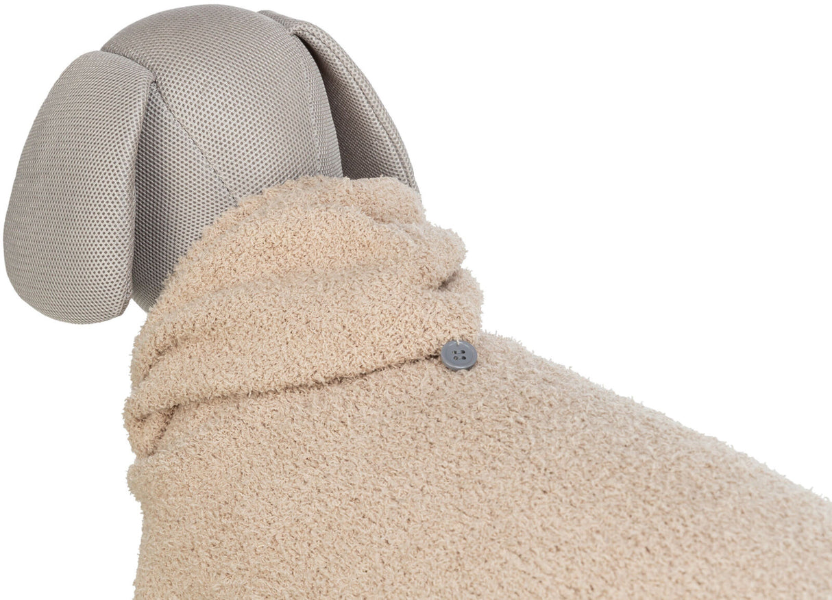 Ein graues Hundemodell mit Ohren trägt einen beigen, flauschigen Mantel, der mit einem Knopf geschlossen ist.