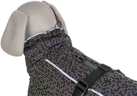 Ein Hundemantel mit geometrischem Muster in Lila- und Schwarztönen auf einem grauen Stoffhintergrund.