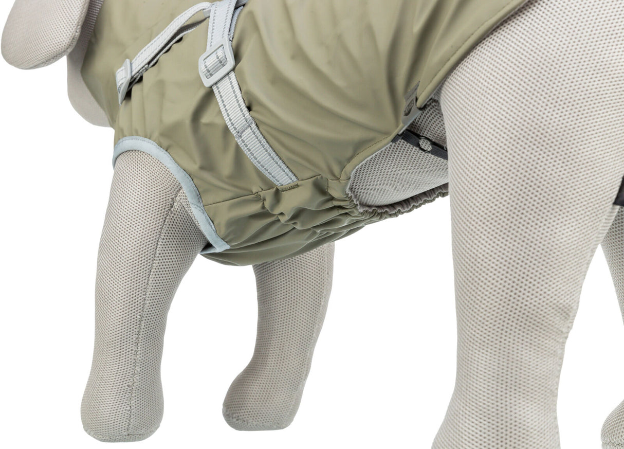 Beige Hundemantel mit hellgrauen Details und Schnallen auf einem weißen Stoffmodell mit Netzstruktur.