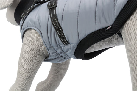 Grauer Hundemantel mit schwarzem Rand und Schnallen auf einem grauen Stoffmodell.