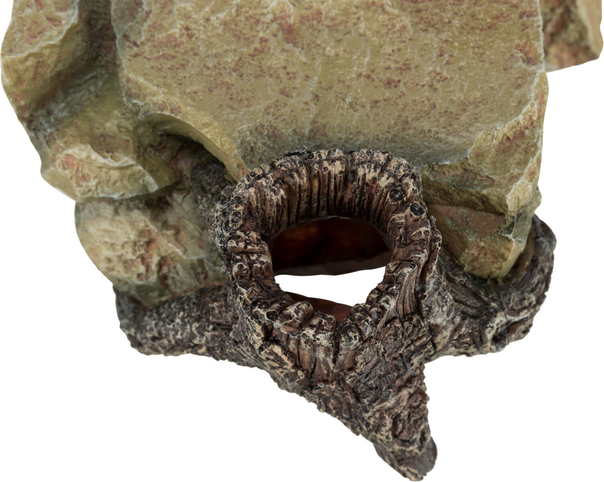 Steinfigur in erdigen Tönen mit runder Öffnung, die wie eine natürliche Höhle wirkt.