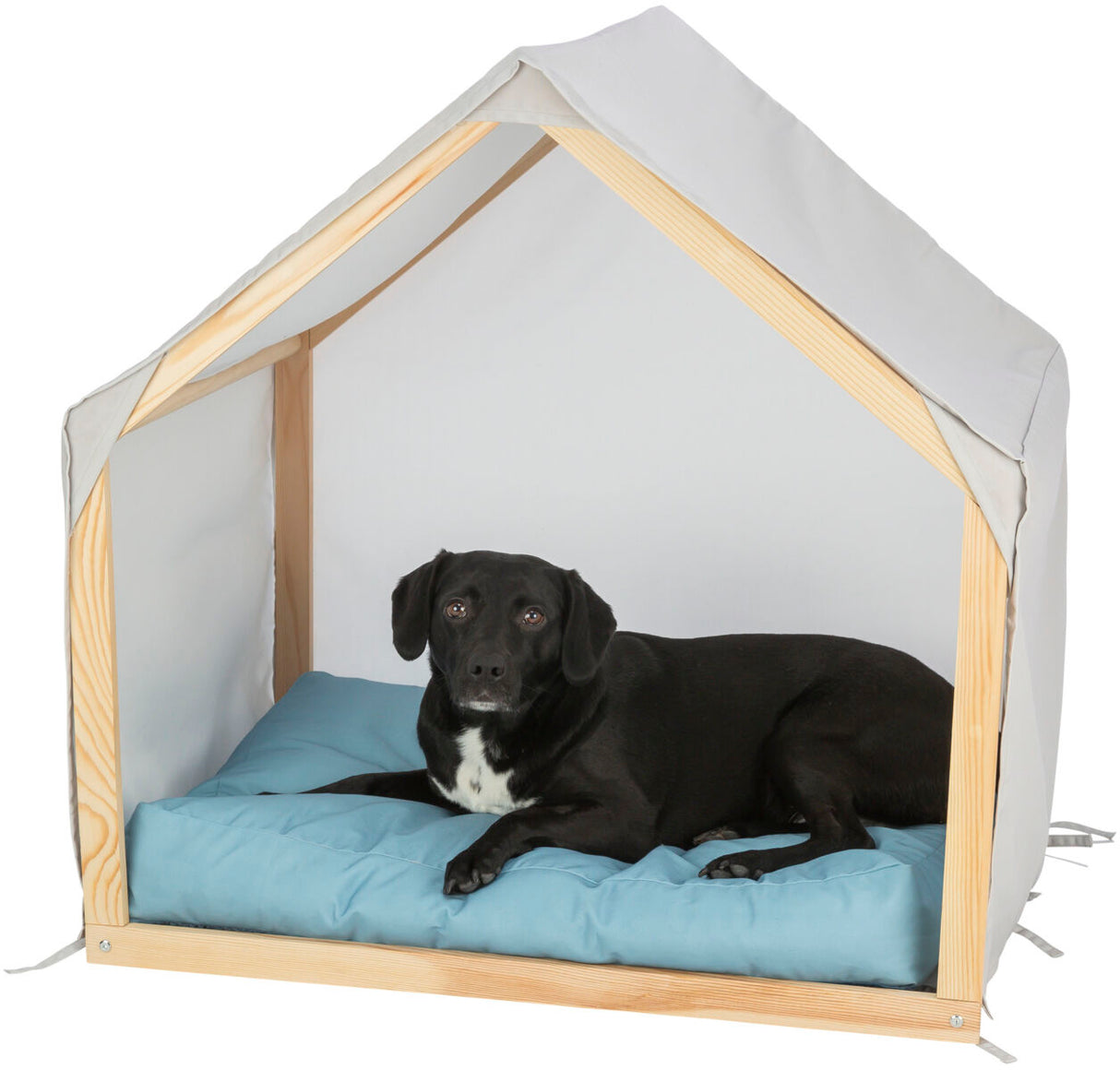 Ein schwarzer Hund liegt auf einem blauen Kissen in einer offenen Holzstruktur mit weißem Stoffdach.