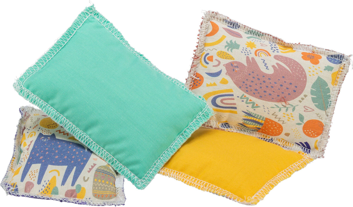 Vier bunte Stoffkissen mit bunten Mustern und gehäkeltem Rand in den Farben Grün, Gelb, Blau und Beige.