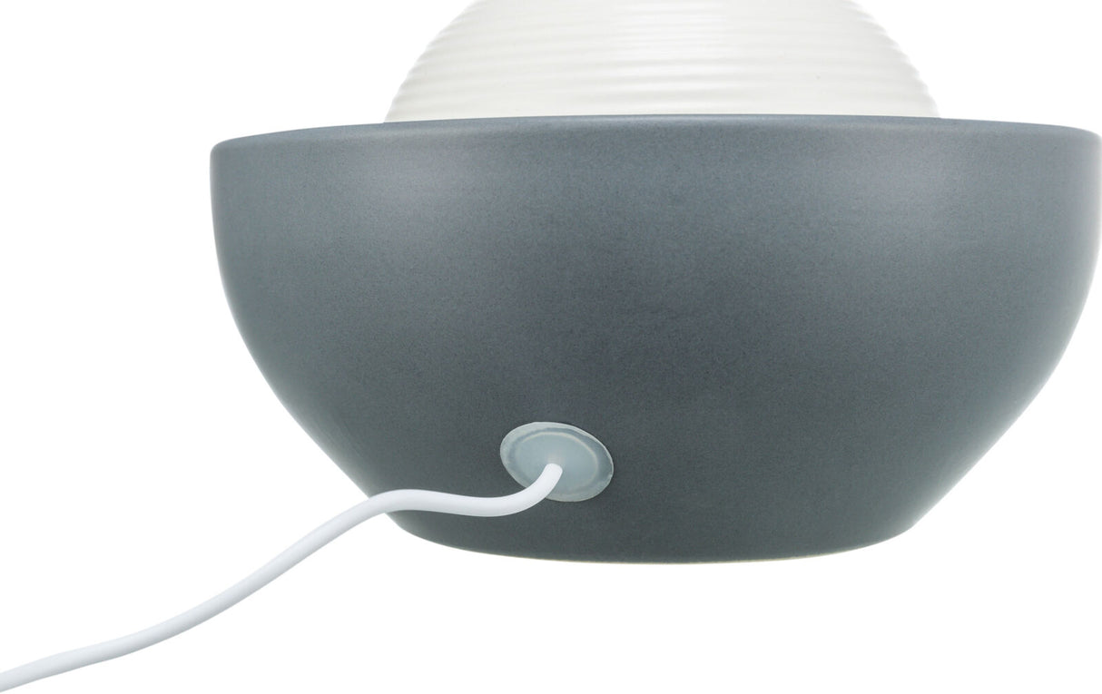 Graue Halbschale mit geriffelter weißer Kugel oberhalb und weißem Kabel, eingesteckt an der Unterseite.