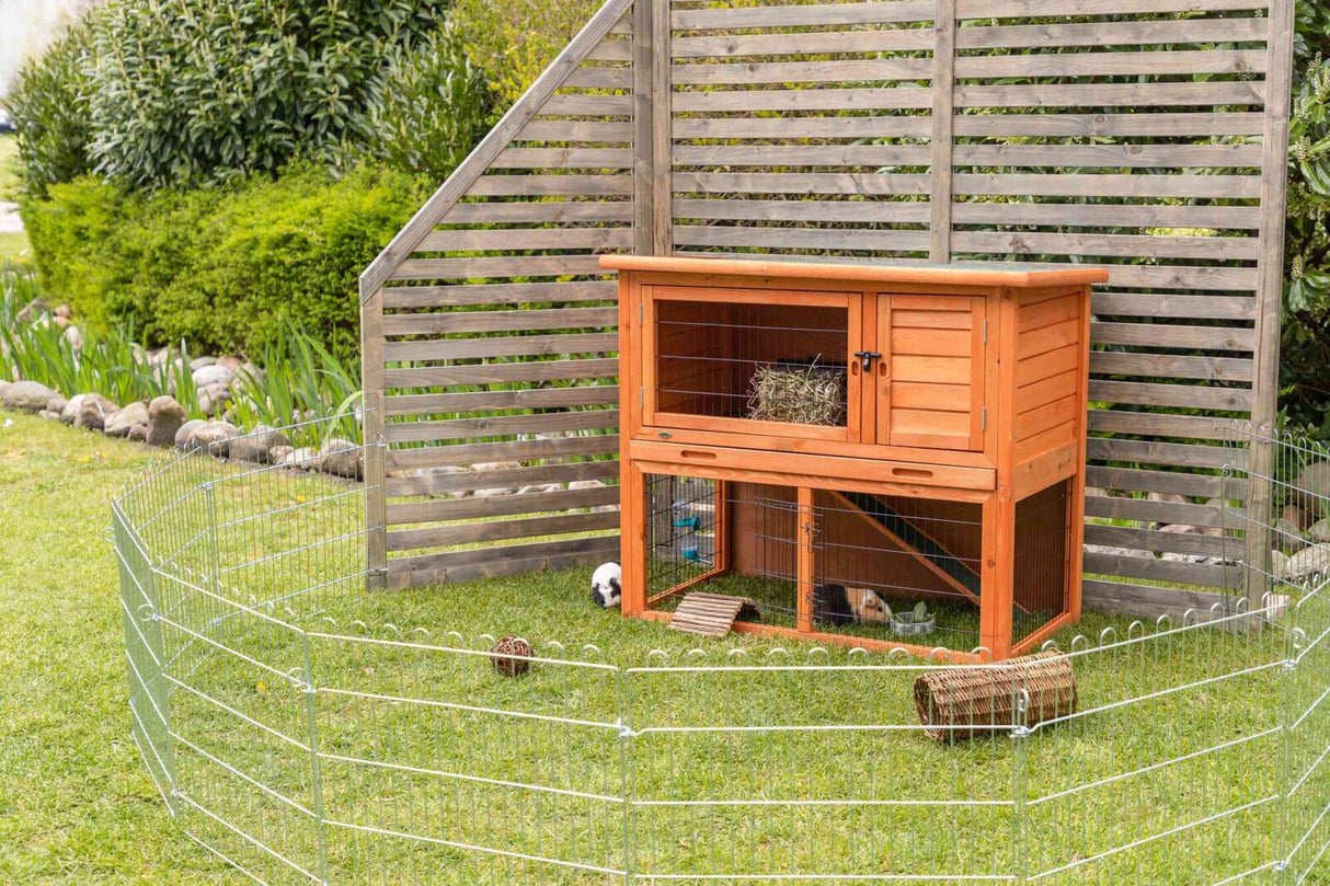 Holzstall mit zwei Ebenen und Drahtgitter im Freien, umgeben von Zaun; innen befinden sich zwei Meerschweinchen.