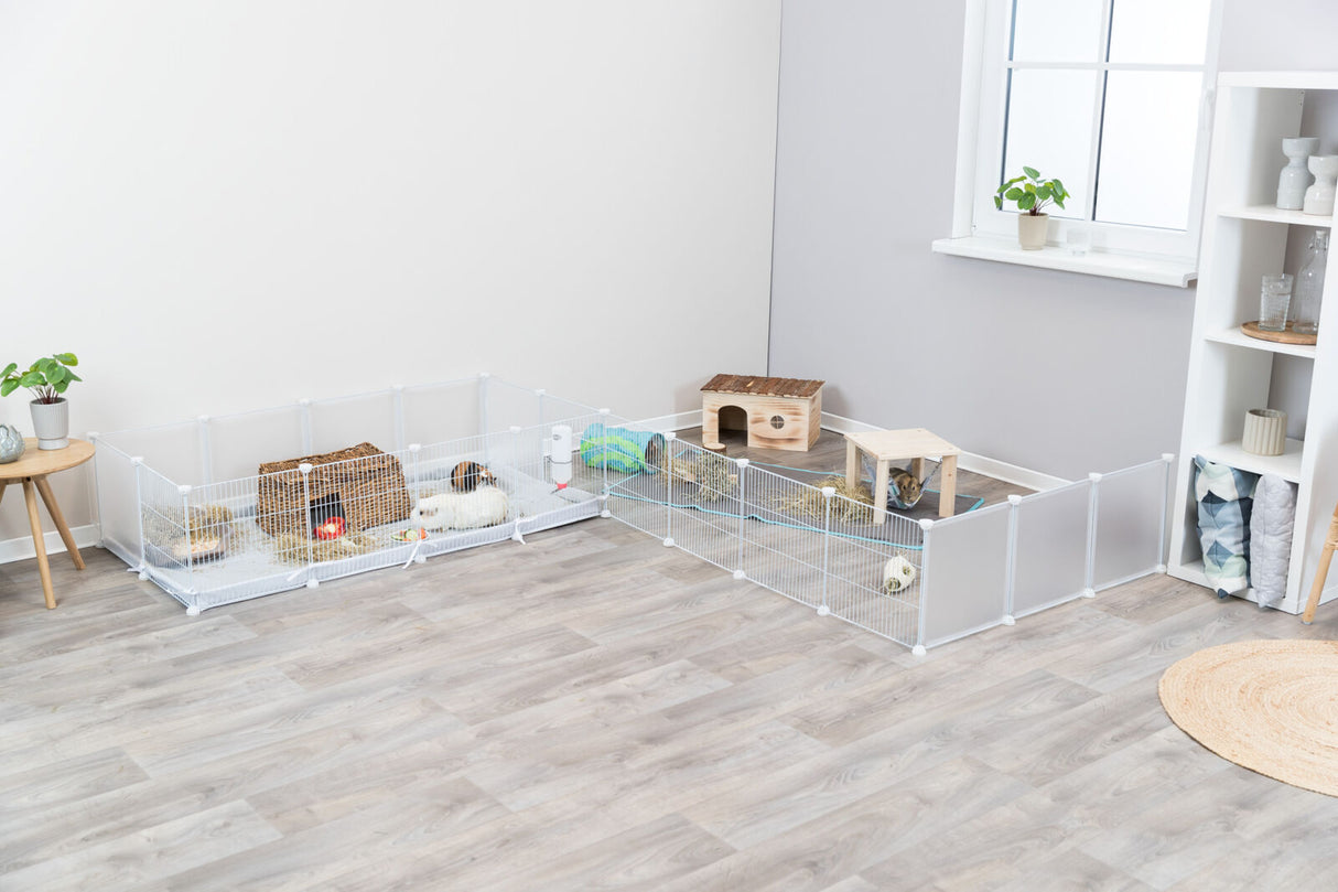 Kleintiergehege mit Meerschweinchen und Kaninchen, Holzhäuschen und Futter, im hellen Innenraum mit Holzboden.