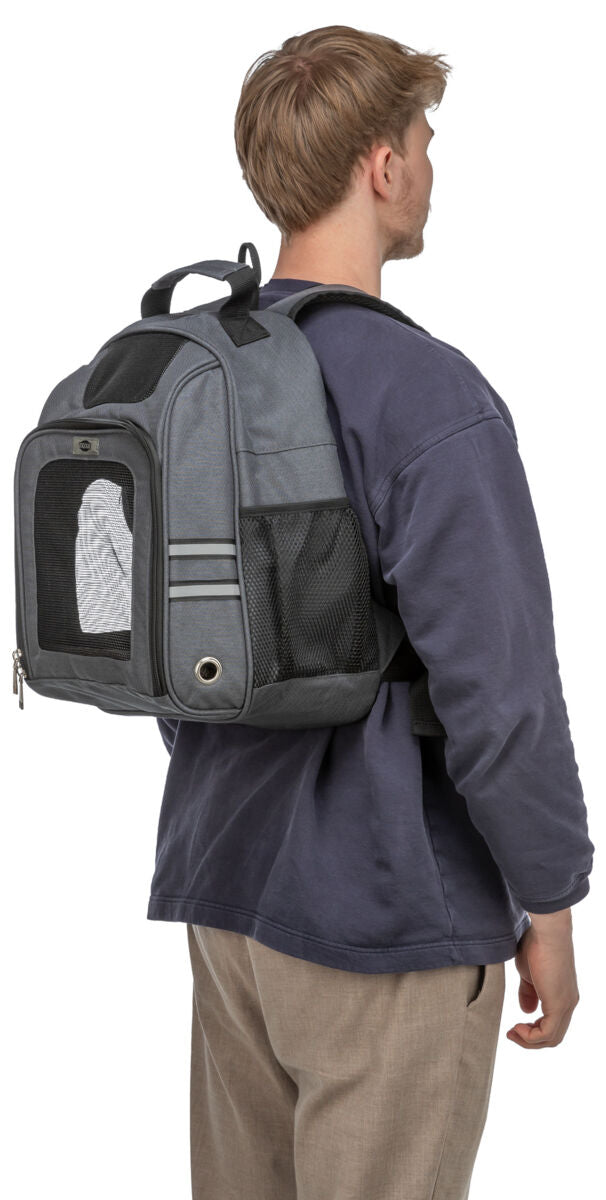 Mann in blauem Pullover trägt graue Rucksack-Tragetasche mit Netzfenster und reflektierenden Details.