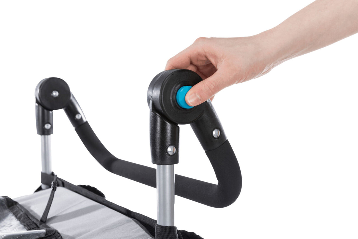 Hand drückt blauen Knopf an schwarzem Griff eines zusammenklappbaren Mechanismus mit Metallstreben.