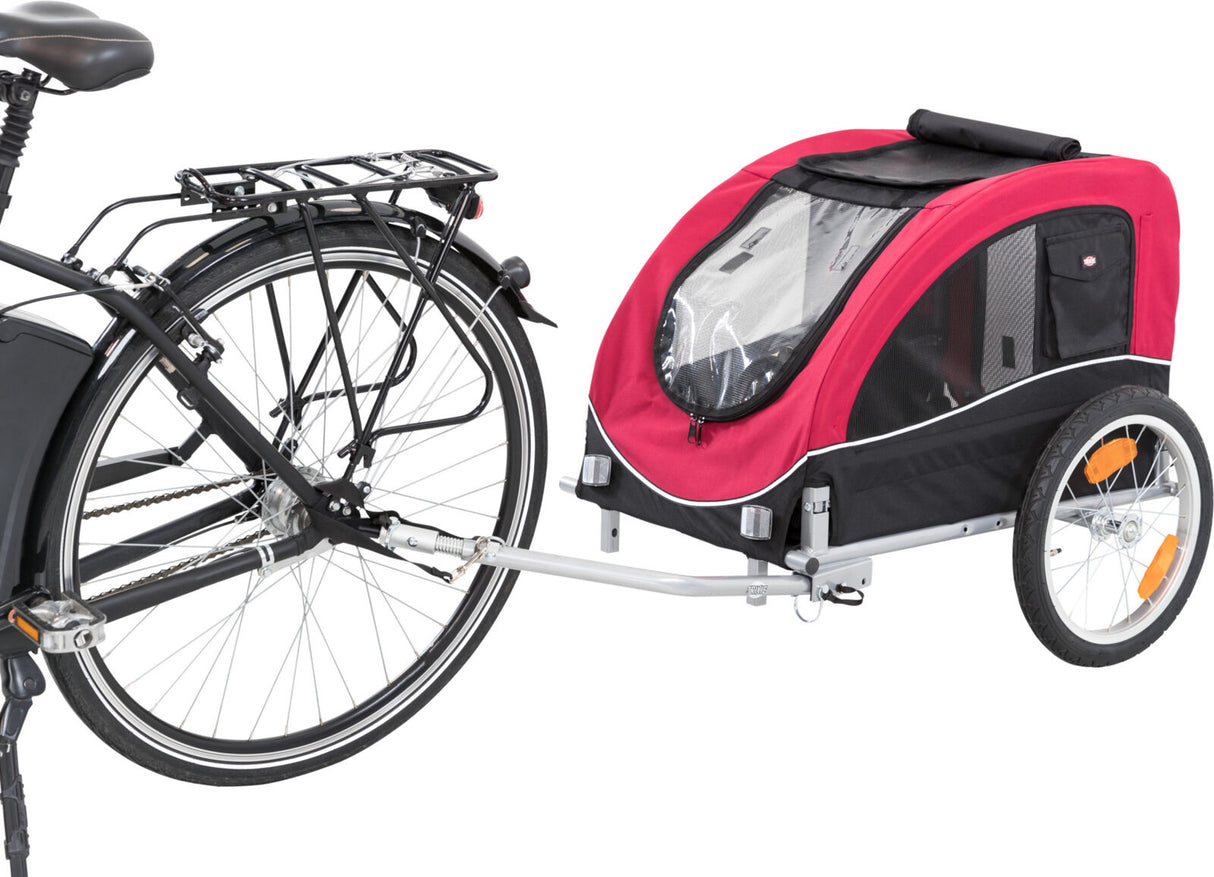 Ein Fahrradanhänger mit roter und schwarzer Verkleidung ist an ein Fahrrad angeschlossen, hat zwei Räder und ein durchsichtiges Fenster.