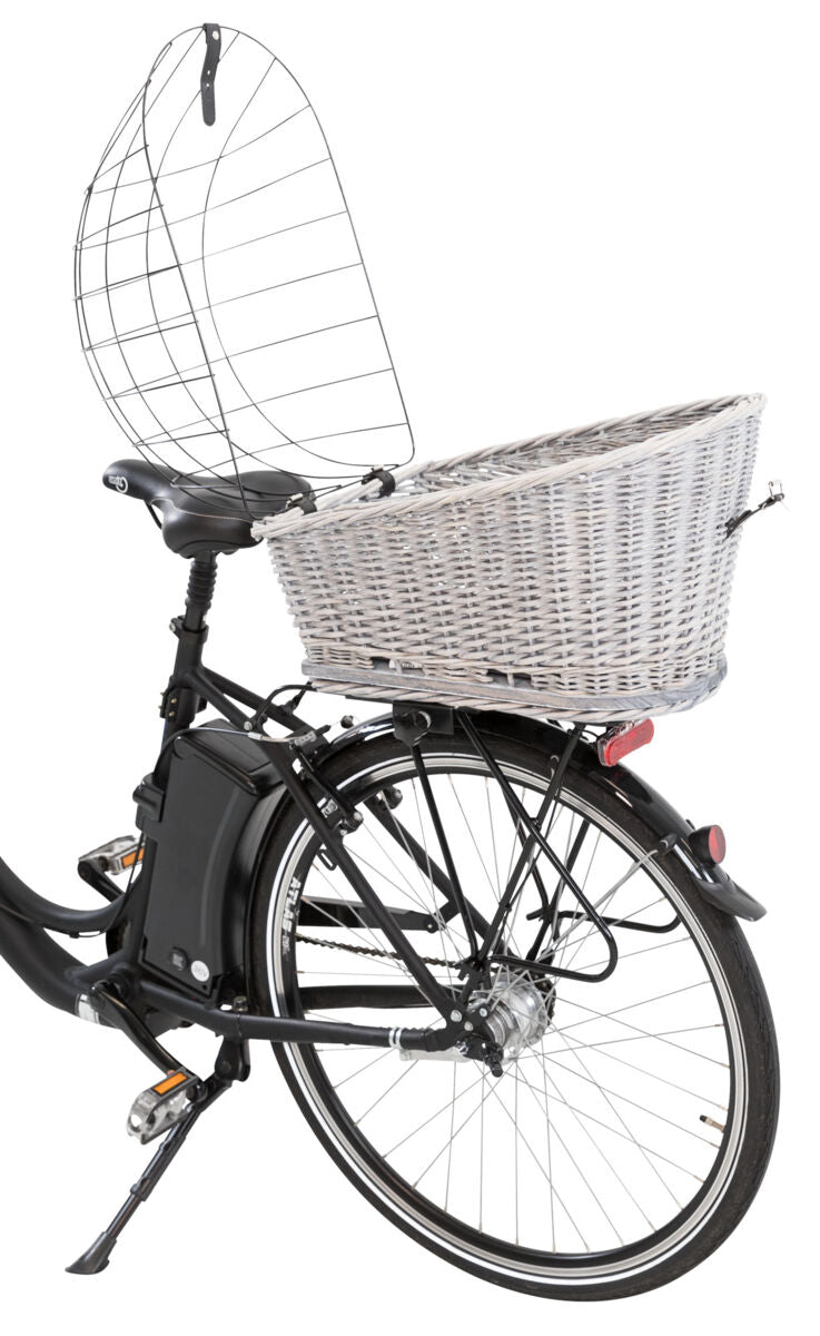 Fahrrad mit Korb hinten und einem Drahtschutz, der Korb ist aus hellem Geflecht, das Fahrrad hat schwarze Reifen.