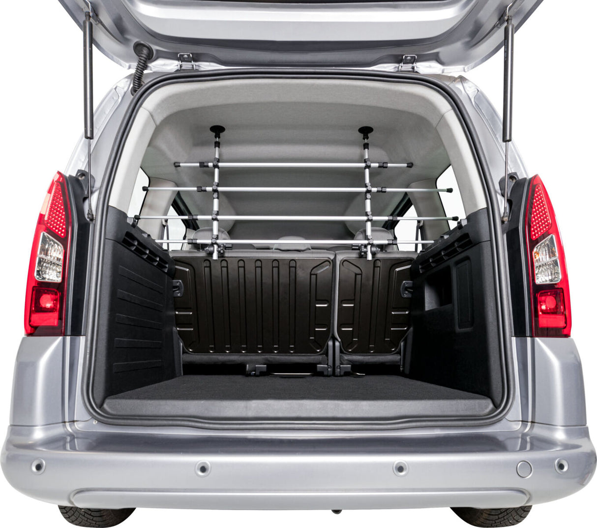 Der geöffnete Kofferraum eines silbernen Fahrzeugs mit einer schwarzen Trennwand und Metallstäben.