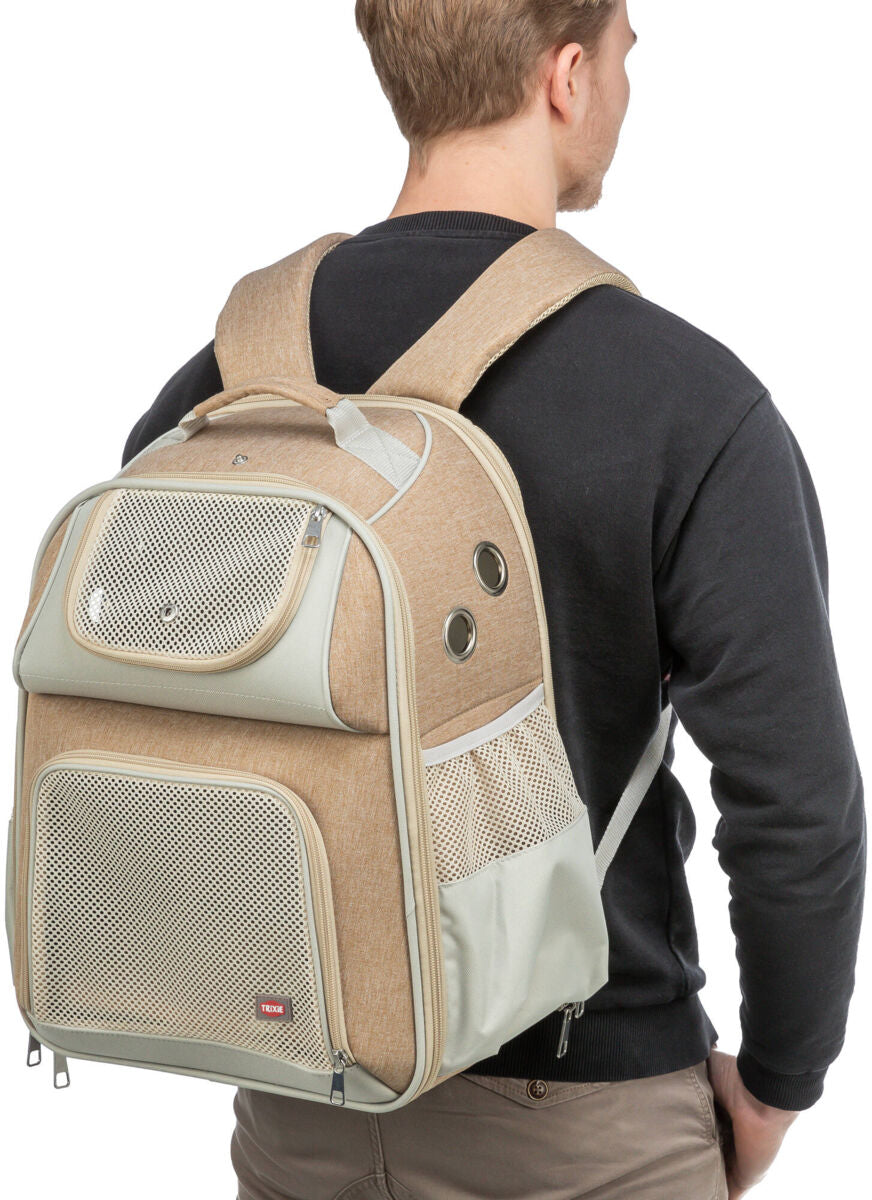Person trägt einen beige-grauen Rucksack mit Netzfächern und Lüftungslöchern auf dem Rücken.