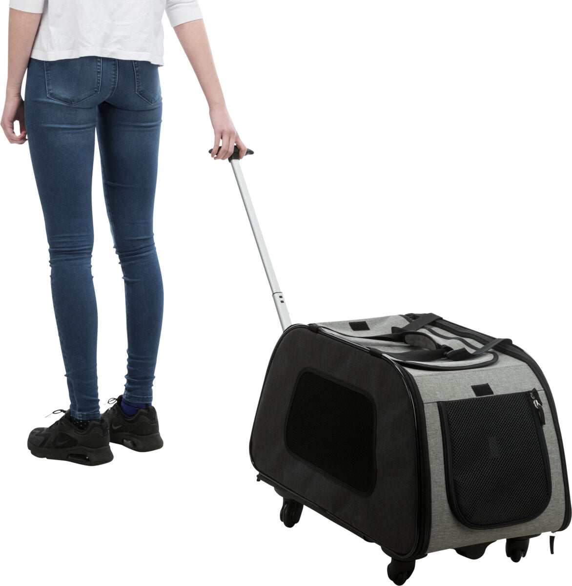 Eine Person in Jeans und Sneakers zieht einen grauen Transportkoffer auf Rollen mit ausziehbarem Griff.