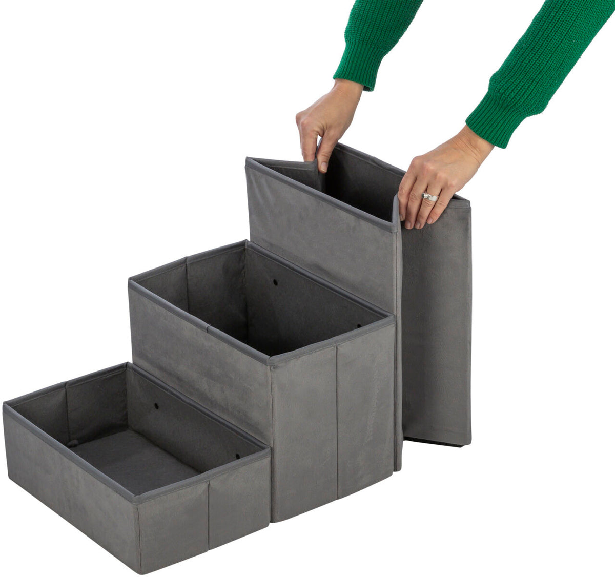 Graue, dreistufige faltbare Aufbewahrungsbox aus Stoff mit einer Person, die die oberste Stufe anhebt.