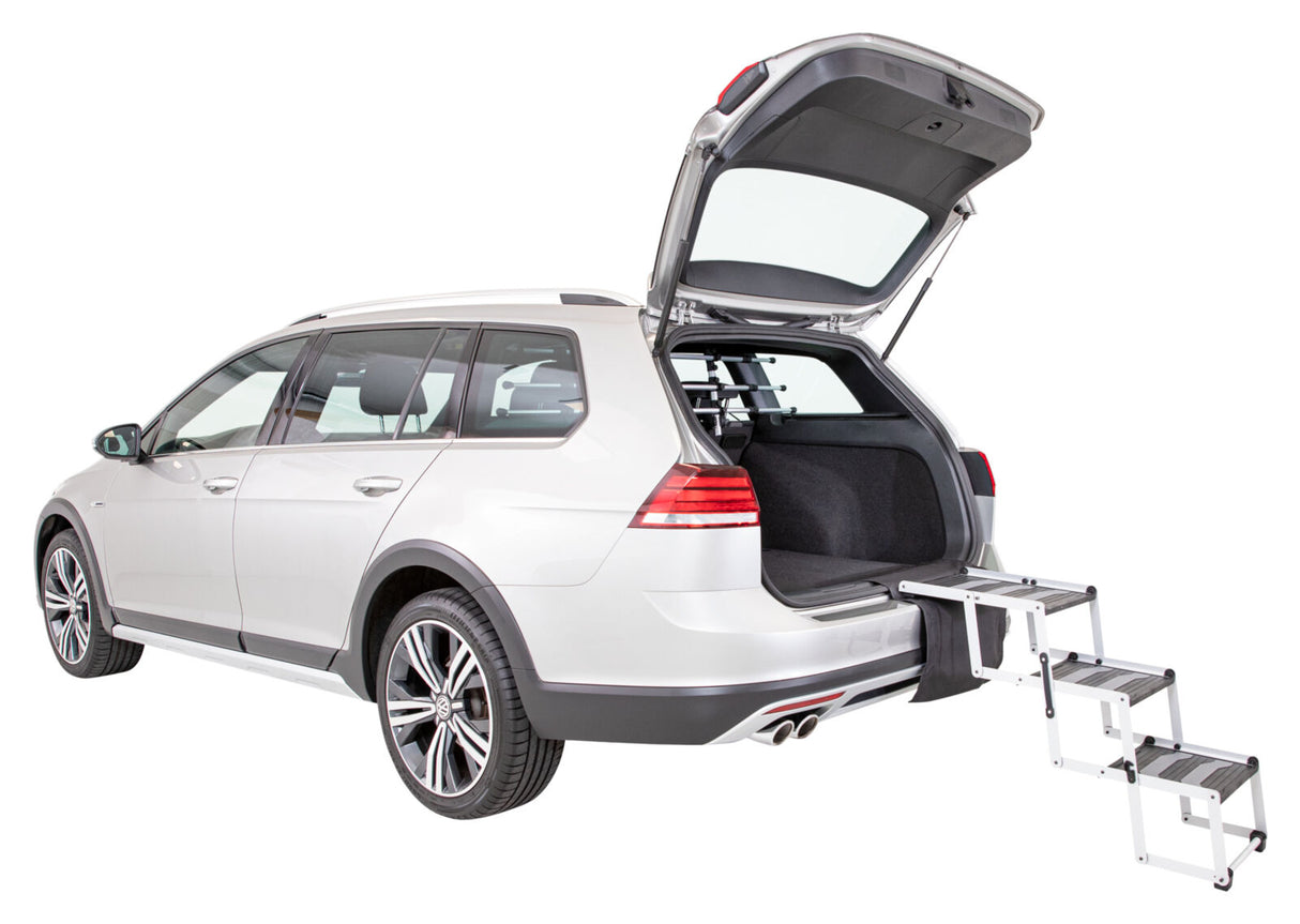 Silberner Kombi mit geöffneter Heckklappe, an der eine ausziehbare Treppe befestigt ist.