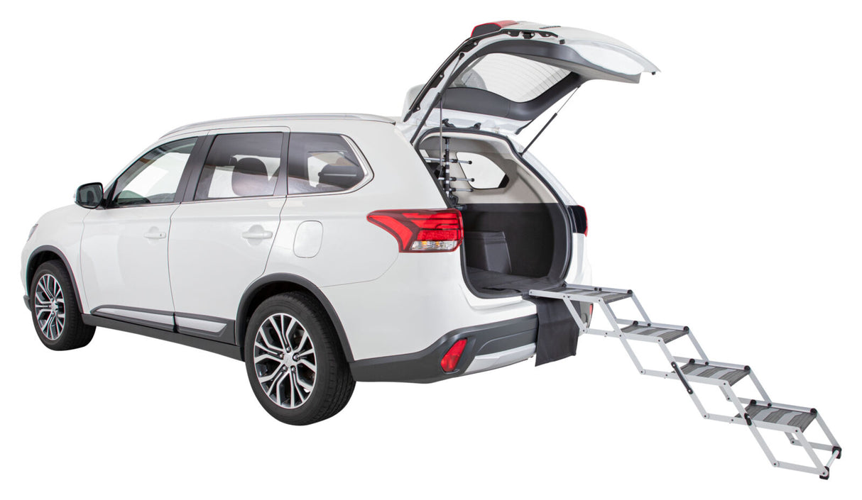Ein weißes Auto mit offener Heckklappe und einer ausziehbaren, gestuften Rampe nach hinten.