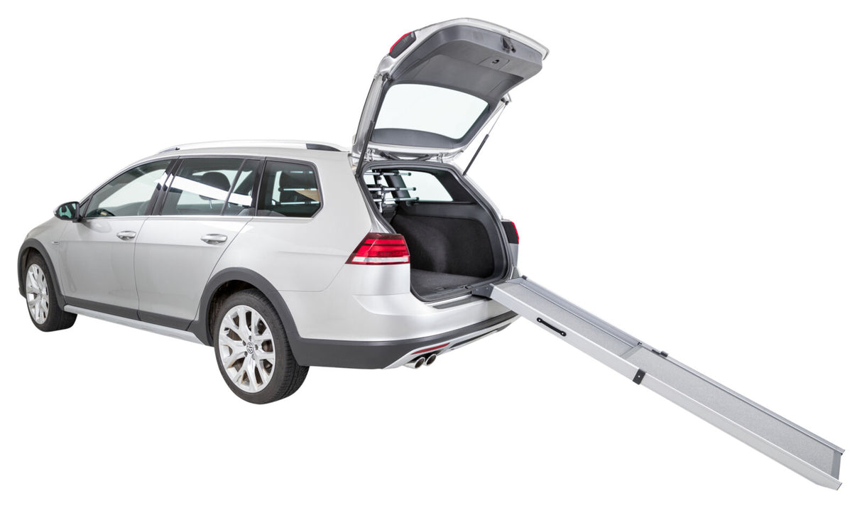 Silberner Kombi mit geöffneter Heckklappe und ausgezogener Rampe, die aus dem Kofferraum führt.