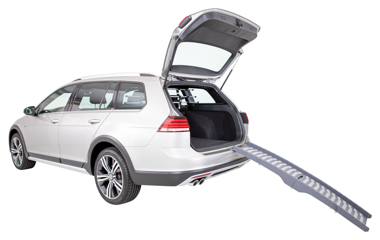 Silberner Kombi mit geöffneter Heckklappe und ausgeklappter grauer Rampe am Kofferraum, passend zum Fahrzeug.