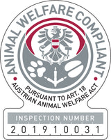 Graues Siegel mit rot-schwarzem Adler und Text: "Animal Welfare Compliant, Pursuant to Art. 18 Austrian Animal Welfare Act".