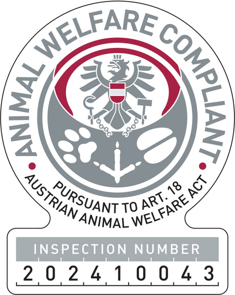 Ein kreisförmiges Logo mit grauem und rotem Adler, Text "Animal Welfare Compliant", "Pursuant to Art. 18 Austrian Animal Welfare Act", und Inspektionsnummer 202410043.
