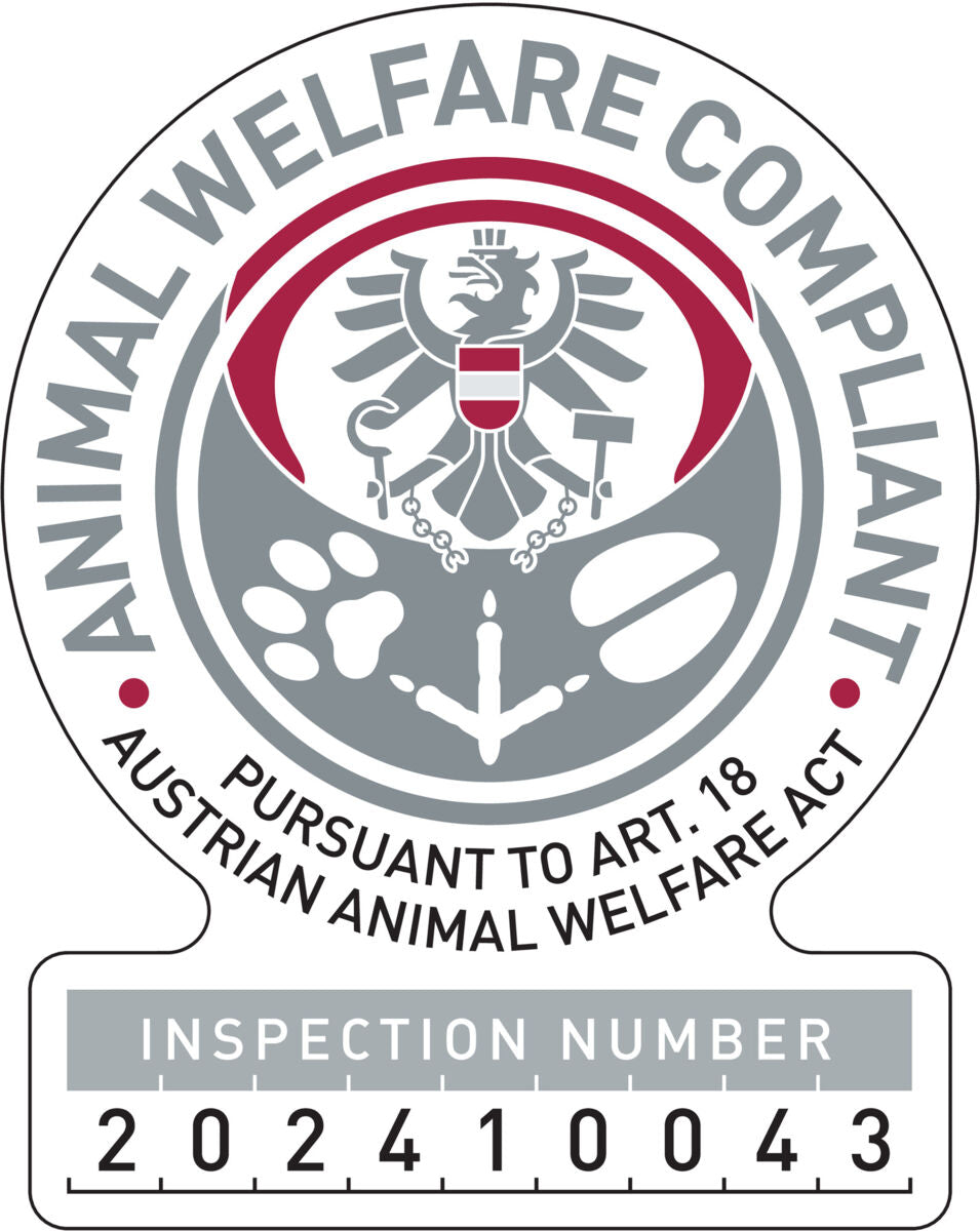 Ein kreisförmiges Logo mit grauem und rotem Adler, Text "Animal Welfare Compliant", "Pursuant to Art. 18 Austrian Animal Welfare Act", und Inspektionsnummer 202410043.