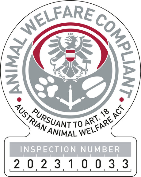 Siegel mit Adler, roten und grauen Kreisen und Text: "Animal Welfare Compliant, Pursuant to Art. 18 Austrian Animal Welfare Act" sowie "Inspection Number 202310033".