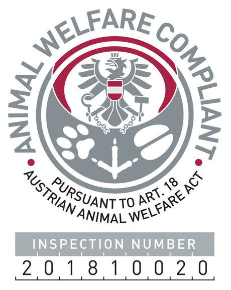 Grau-rote Abzeichen mit Adler, Pfotenabdruck und Text "Animal Welfare Compliant" sowie Prüfnummer 201810020.