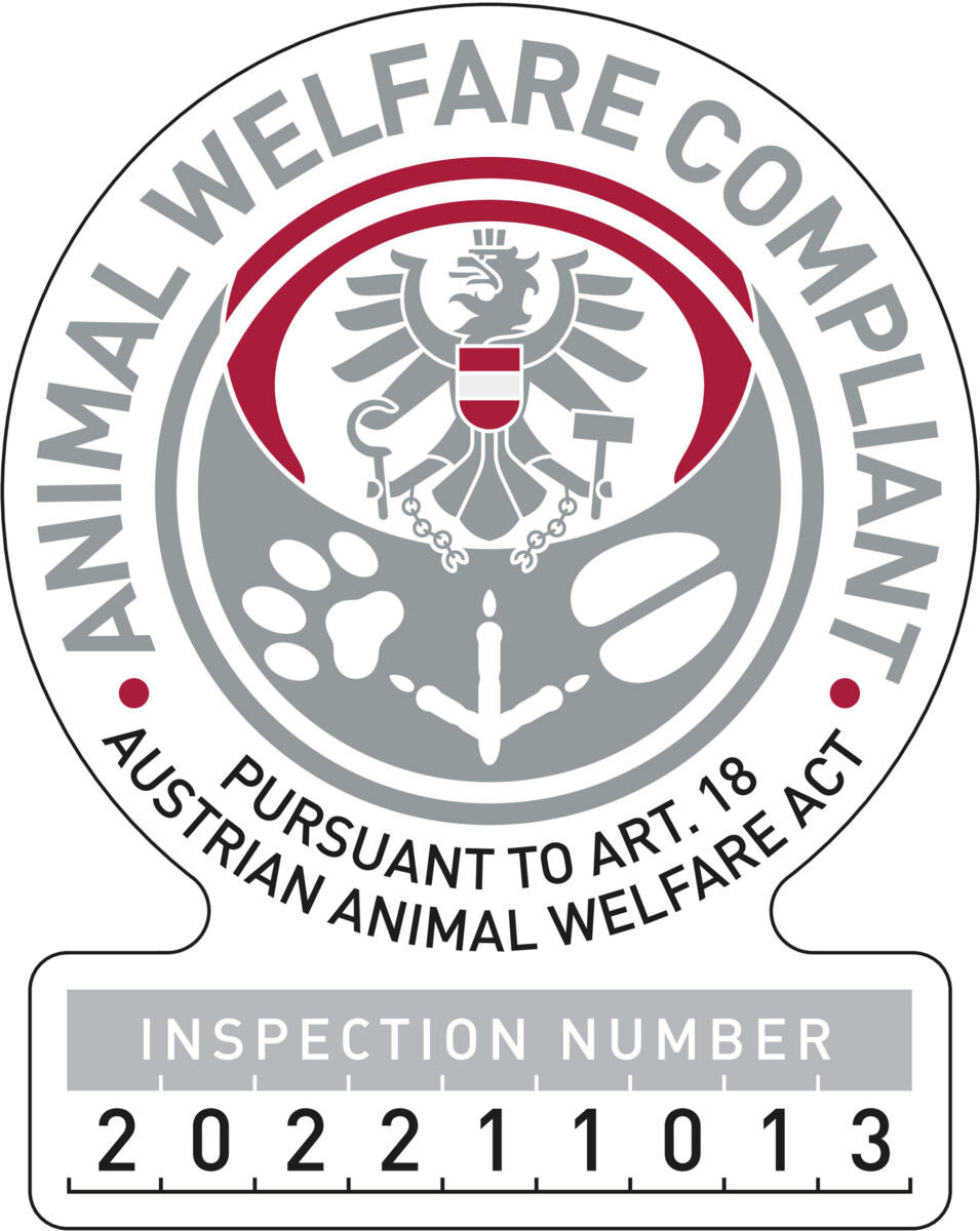 Graues und rotes Siegel mit Text „ANIMAL WELFARE COMPLIANT“ und „PURSUANT TO ART. 18 AUSTRIAN ANIMAL WELFARE ACT“.