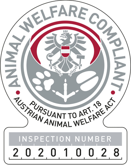 Rundes Emblem mit Adler, Tatzenabdrücken, griechischer Spalte, Text: "ANIMAL WELFARE COMPLIANT" und Inspektionsnummer.