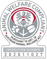 Rundes Emblem mit einem Adler, Tatzenabdrücken und einem Anker, Text: "ANIMAL WELFARE COMPLIANT" und "INSPECTION NUMBER 202011027".