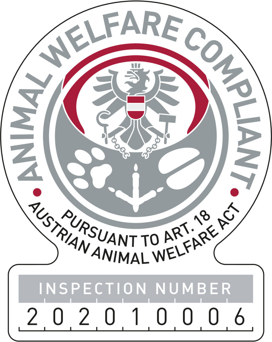 Graues und rotes Abzeichen mit einem Adler und Text: "Animal Welfare Compliant, Pursuant to Art. 18 Austrian Animal Welfare Act, Inspection Number 2020100006".