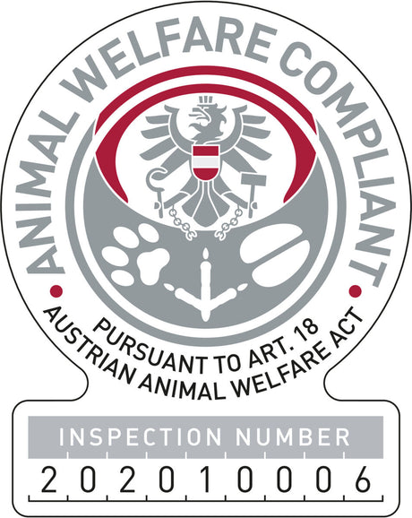 Graues und rotes Abzeichen mit einem Adler und Text: "Animal Welfare Compliant, Pursuant to Art. 18 Austrian Animal Welfare Act, Inspection Number 2020100006".