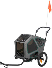 Grau-schwarzer Fahrradanhänger mit zwei Rädern und orangener Fahne, rechteckige Form, mehrere Fenster.