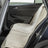 Beige Sitzschoner bedeckt Rücksitz eines geöffneten Autos.
