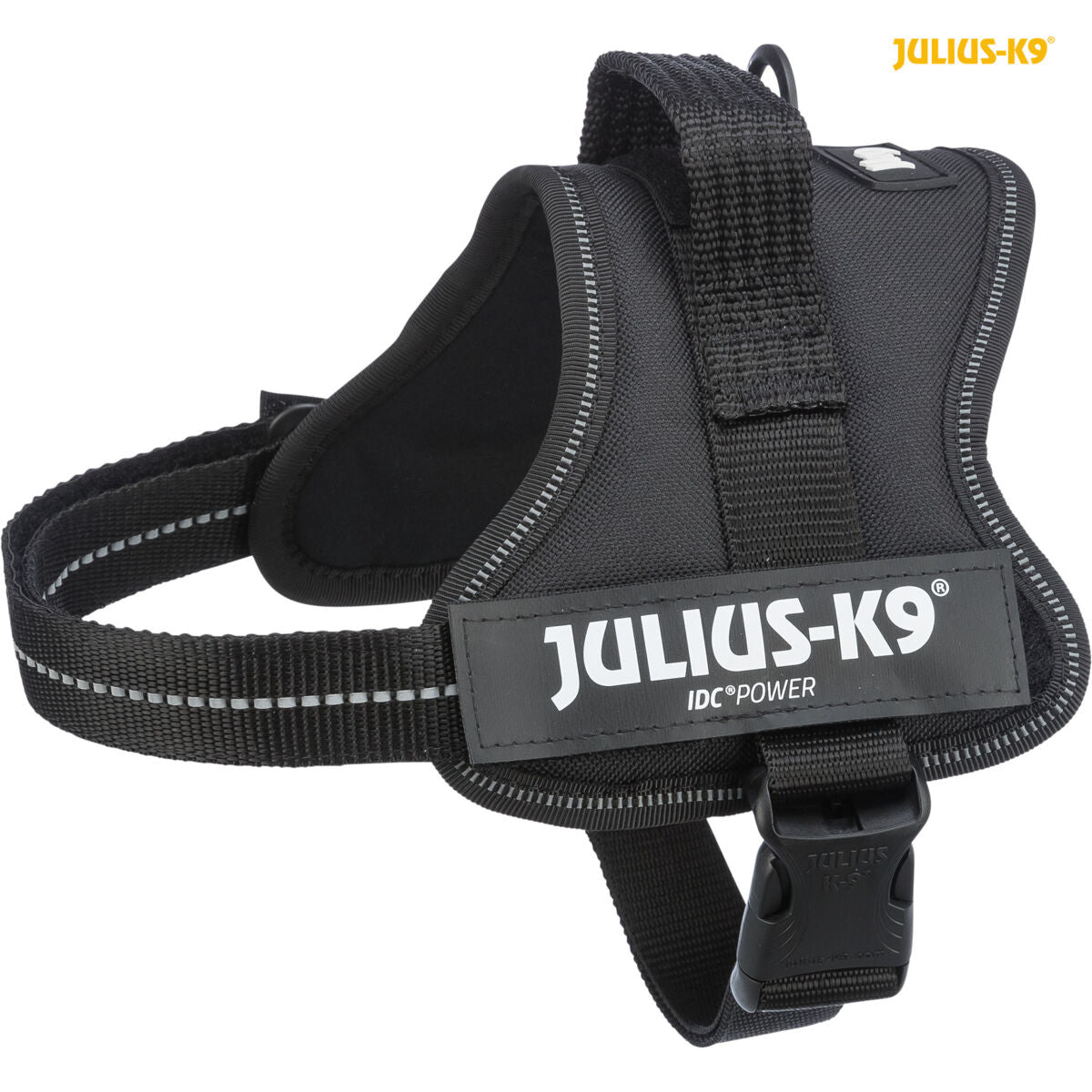 Schwarzes Hundegeschirr mit der Aufschrift "Julius-K9" und reflektierenden Streifen, hinten eine Schnalle.