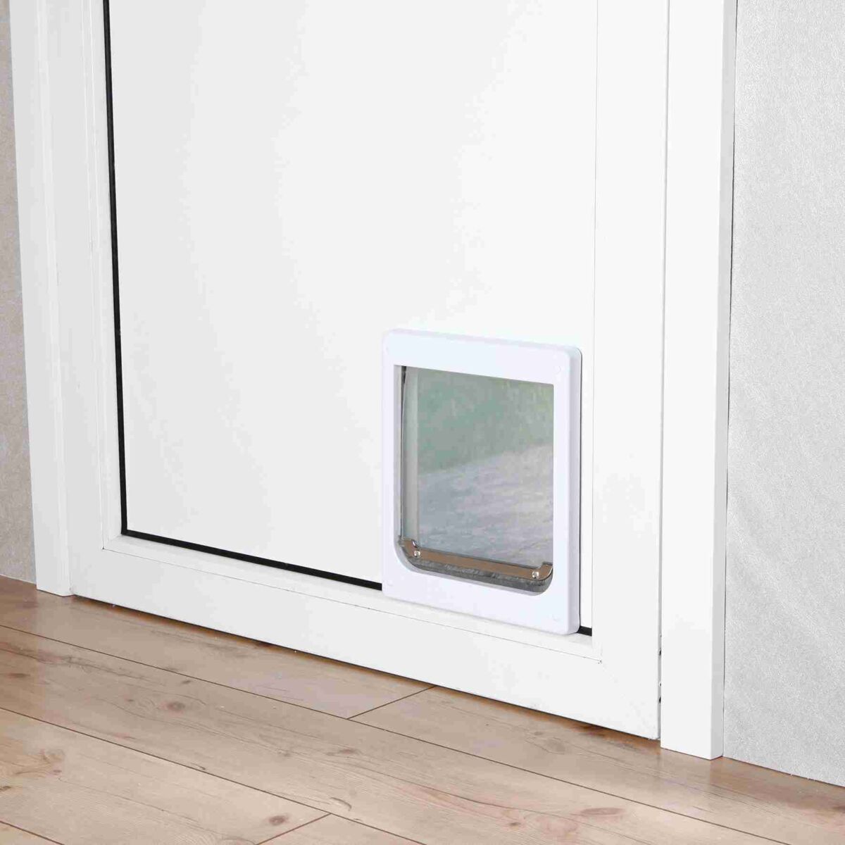 Weiße Tür mit eingebauter rechteckiger Katzenklappe aus Kunststoff, Boden mit hellen Holzpaneelen.