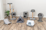 Mehrere graue Katzenmöbel und eine Katzentoilette auf einem Holzboden vor einer weißen Wand.