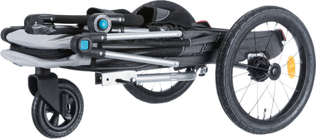 Gefalteter Fahrradanhänger mit schwarzem und grauem Gestell, drei Rädern und sichtbarem Reflektor.