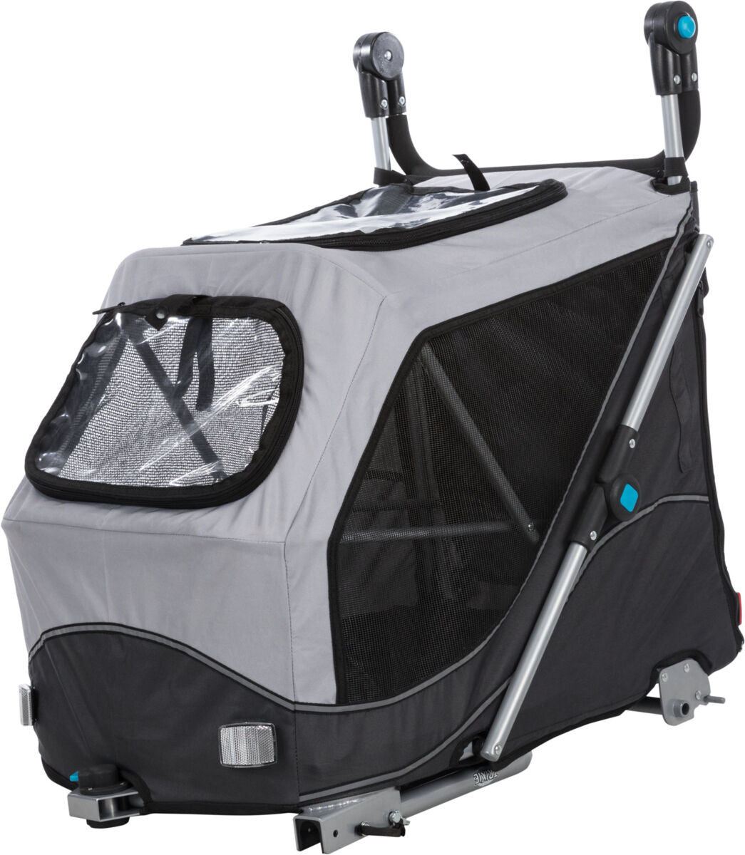 Grau-schwarzer Fahrradanhänger mit Netzfenstern und Metallrahmen, Rückenstützen oben; sichtbar sind Halterungen und Griffe.