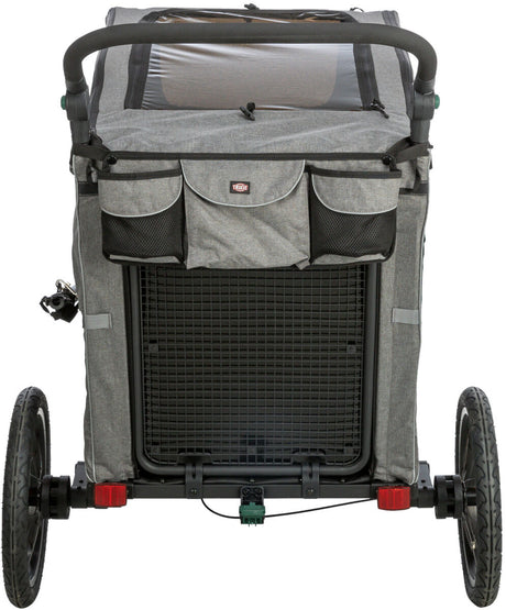 Ein grauer Fahrradanhänger mit zwei Rädern, oben mit Netzabdeckung und Griff, auf Asphalt stehend.