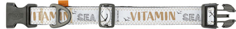 Hundehalsband mit schwarzer Schnalle, weißem Stoff mit brauner Schrift "VITAMIN SEA" und nautischen Symbolen.