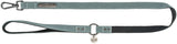 Grüne Hundeleine mit Metallschnalle und Karabinerhaken, schwarzer Griff, silberner Anhänger mit "TRIXIE"-Logo.