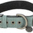 Ein grünes Hundehalsband mit Metallösen, Schnalle, D-Ring und einem Anhänger mit der Aufschrift "Trixie".